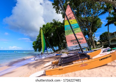 Bright Catamarans Hauled Up On Fine Pink Sand Under Hot Afternoon Sun, Including One Called Miserable Git, At A Resort On Paynes Bay Beach, West Coast, Barbados, Caribbean, West Indies 11.22.19