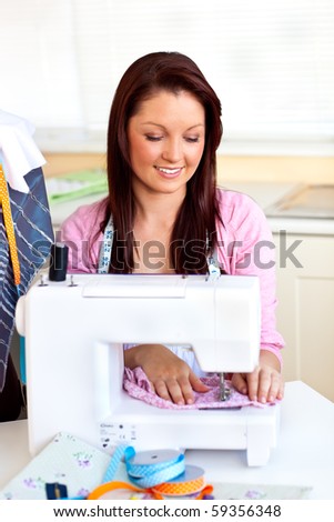 Bright caucasian woman using a sewing-machine in the kitchen at home