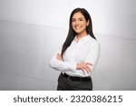 A bright and cheerful finance business woman, hispanic executive, boss, CEO, entrepreneur, student, smiling and standing confidently with arms crossed	