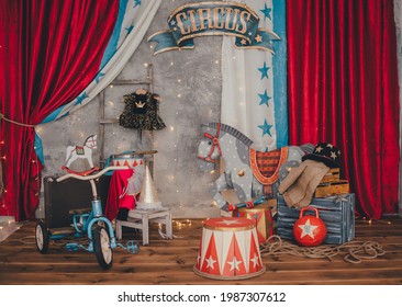 Bright circus decorations. The decoration of kettlebells, digital curbstones, a beautiful painted horse, drums, gymnastic clubs on the background of a gray wall. Circus concept. Horizontal frame.