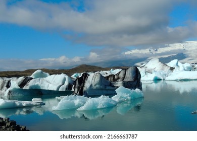 Bright clear blue and black stripped icebergs floating in the Jokulsarlon lake blue cold water in Iceland iceberg floating in the Jokulsarlon lake blue cold water in Iceland