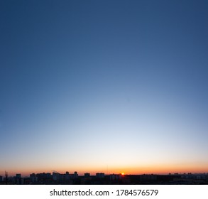 Bright clear blue sky and sun in sunset over buildings of city, bright panorama landscape background