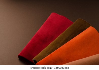 A bright collection of red, brown and orange colorful velour textile samples. Fabric texture background