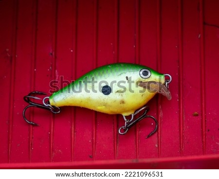 Bright colored crank bait fishing lure in a tackle box.