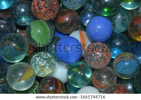 Bright colored glass balls that are assembled in a container.
