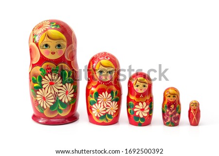 Bright colored nesting dolls on a white background. Russian national souvenir. A row of red nesting dolls of different sizes. Handmade work. Authentic Russian souvenir, hand-painted nesting dolls