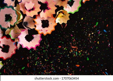 bright colored pencil trimmings on a black background - Powered by Shutterstock