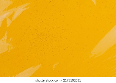 Bright colored transparent gift box. Glitter paper under cellophane. Background with copy space or backdrop. Yellow