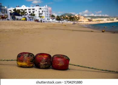 Bright Colored, Weathered Floats On A Beach In Cabo San Lucas, Mexico