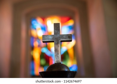 bright colorful church window with a cross in front of it - Powered by Shutterstock