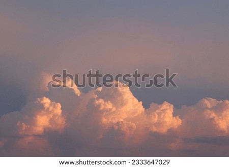 Bright colorful cumulus clouds on sunset sky. Background cloudscape wallpaper with copy space.