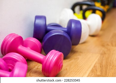 Bright Colorful Dumbbells On The Floor In The Gym