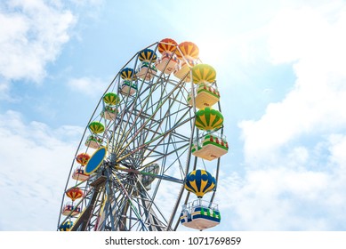 Bright colorful Ferris wheel against the blue sky.