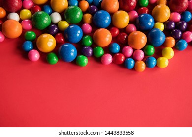 Bright And Colorful Gum Balls On Red Background