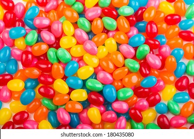 Bright, colorful jellybeans in red, green, pink, blue, yellow and orange colors.