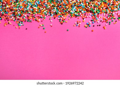 Bright Colorful Sprinkles On Pink Background, Flat Lay With Space For Text. Confectionery Decor