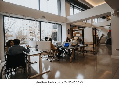 A bright, contemporary office space with a diverse group of professionals working together. Includes a person using a wheelchair, promoting inclusivity. - Powered by Shutterstock