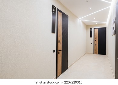 a bright corridor with dark doors and bright lighting. New house