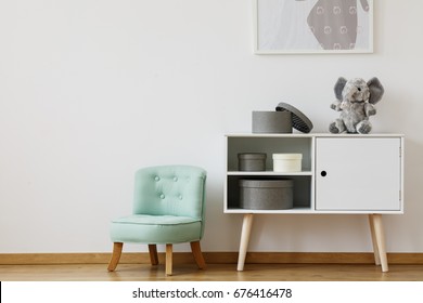 Bright cupboard standing next to mint chair for children