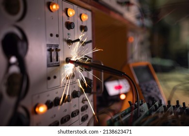 Bright Dangerous Electronic Sparks Of Current Quickly And Sharply Scatter From An Unsafe Short Circuit On Complex Technological Equipment, In A Dark Room With Electrical Appliances