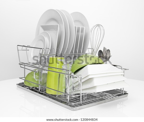 Bright dishes drying on a metal dish rack.\
White background.