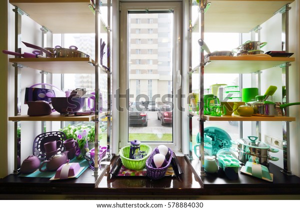 Bright dishes are on shelves on windowsill in Good for\
Home shop 