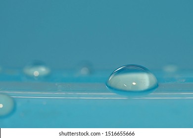 bright drop of water similar to a contact lens with a blue background - Powered by Shutterstock