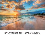 Bright and dynamic sea beach sunrise with bright blue skies and colorful clouds