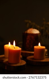 Bright Easter burning candles with Easter cake on dark black background on natural wooden candlesticks with willow branch on a table. Closeup warm concept, Easter holiday. No people