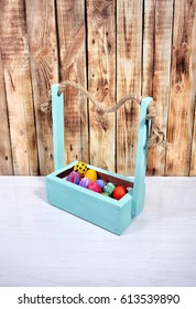 
Bright Easter eggs in a colored basket. Testicles in a wooden box. The painted Easter eggs on a virgin background