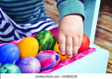 Bright Easter eggs in a colored basket. Testicles in a wooden box. The painted Easter eggs on a virgin background. color easter egg