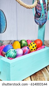 Bright Easter eggs in a colored basket. Testicles in a wooden box. The painted Easter eggs on a virgin background. color easter egg
