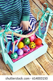 Bright Easter eggs in a colored basket. Testicles in a wooden box. The painted Easter eggs on a virgin background. color easter egg