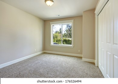 Bright Empty Room With One Window, Beige Carpet Floor, Ivory Walls And Walk-in Closet