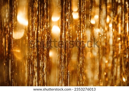 Bright falling confetti gold glitterins ribbons background glistening light twinkle for celebrating new year and christmas. Sparkling bokeh wonderful yellowish sequins garland rain of shiny glitter