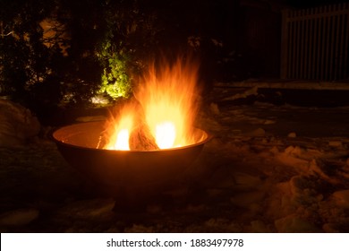 Bright Fire In The Outdoor Fire Pit On A Snowy Winter Night