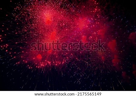 Bright fireworks of different colors and lots of bright sparks of red, blue and orange and smoke on the background of the night sky. High quality photo