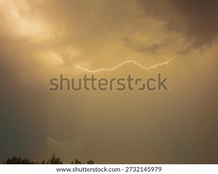 Bright flashes of lightning light up the sky as storm clouds gather, signaling an impending downpour. Thunder rumbles in the distance, heightening the atmosphere.