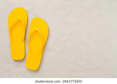 Bright flip-flops on sand background, top view. Summer concept - Powered by Shutterstock