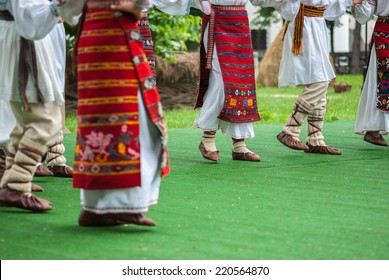 Bright Fragment Of Fast Romanian Folk Dance With Red Girls Skirts And Traditional Sandals