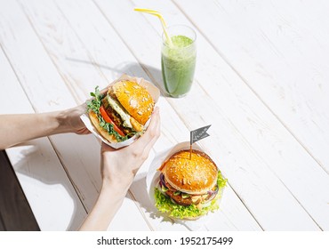Bright Fresh Veggie Burger Without Gluten And Meat. Woman Eating Vegan Burger In A Restaurant And Drinking Green Smoothie
