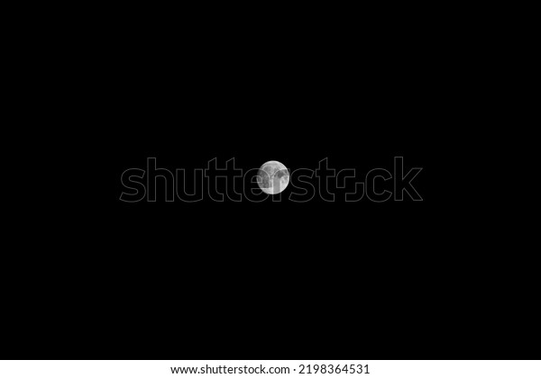 Bright full moon in dark night sky. Satellite\
in space. Round white whole celestial body in dark. Crater on lunar\
surface in detail. Detailed view.  Astronomical. Scary. Lonely.\
Loneliness. Telescope.