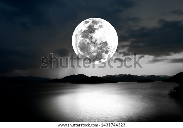 Bright full moon\
over lake in the dark\
night.