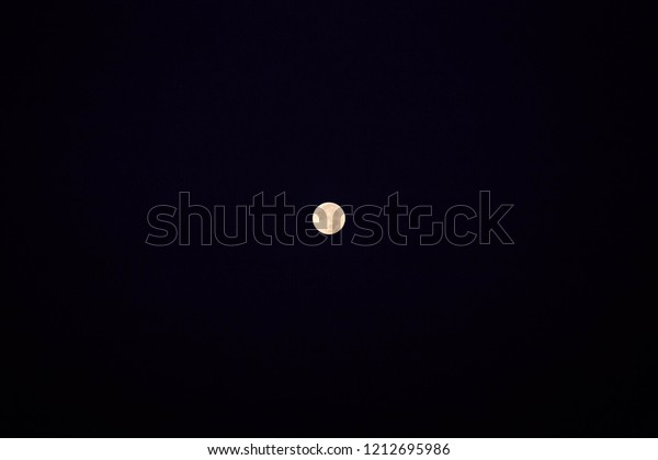 Bright\
full moon shines against dark black\
background