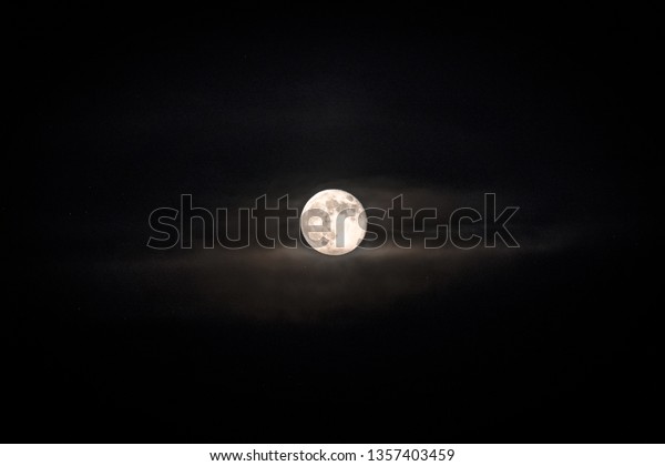 Bright and full\
moon with surrounding\
clouds