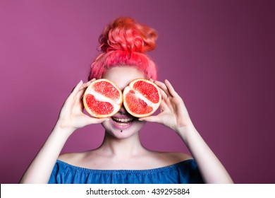 Bright Funny Girl With Pink Hair In A Studio With A Pomegranate