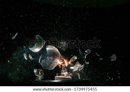 bright glass light buld get exploding while shining with high speed object isolate in dark background stock photo