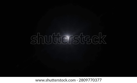 A bright, glowing light source emanates from the center of a dark background, creating a lens flare effect.