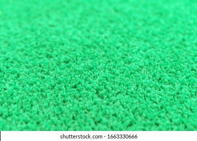 Bright green carpet pile, texture. Focus with shallow depth of field.
