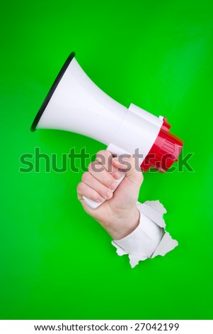 Bright green paper background with white torn hole from which a hand holding a megaphone is emerging.